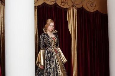 Kraliyet elbise perde zemin üzerinde poz kadın oyuncu