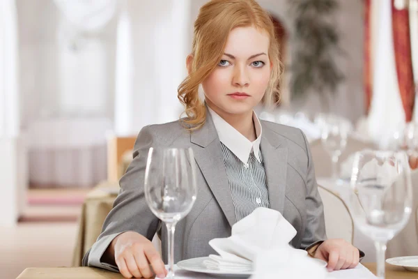 Ernsthafte rothaarige Geschäftsfrau posiert am Tisch — Stockfoto
