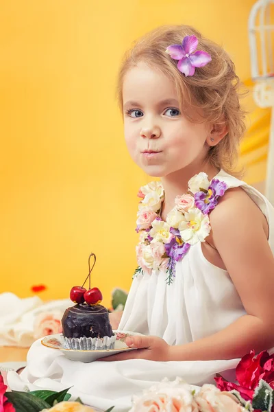 Porträt eines verschmitzt lächelnden Mädchens, das mit Kuchen posiert — Stockfoto