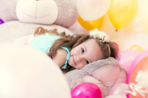 Чарівна маленька дівчинка лежить на плюшевому ведмедику — стокове фото