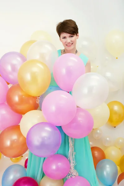 Mulher bonita detém grande monte de balões coloridos — Fotografia de Stock