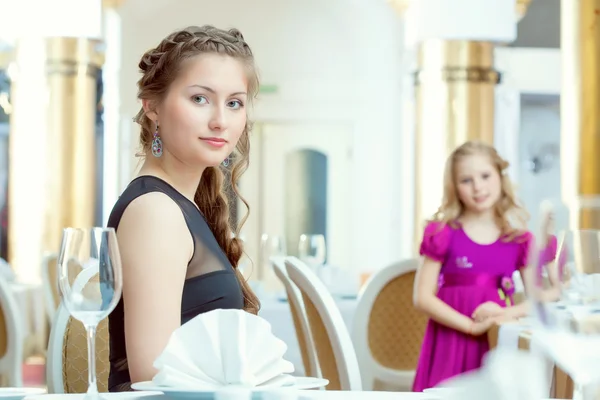 Pretty young sisters posing at restaurant — Stock Photo, Image