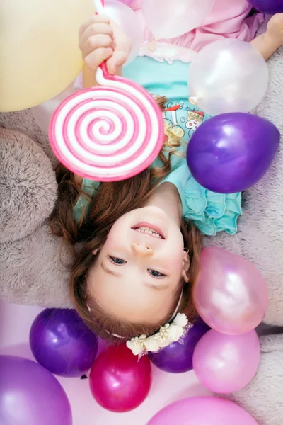 Vue du dessus de joyeuse petite fille posant avec des ballons — Photo