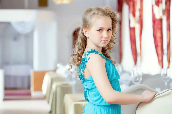 Güzel bir kıvırcık kız zarif Mavi elbiseyle poz — Stok fotoğraf