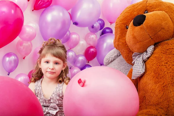 Vackra lockiga flicka poserar bland rosa ballonger — Stockfoto