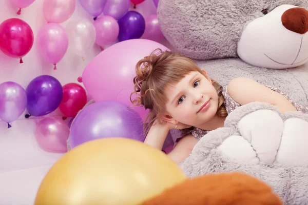 Engraçado menina posando deitado no grande urso de pelúcia — Fotografia de Stock