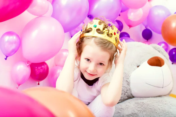 Portret van grappig meisje proberen op kroon — Stockfoto