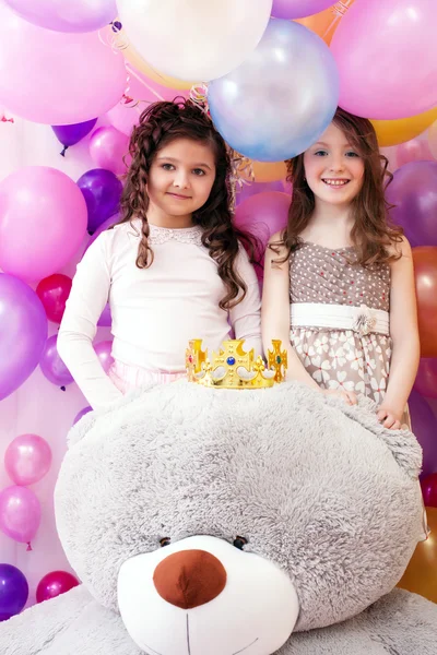 Dos hermanas lindas sonrientes y un gran osito de peluche — Foto de Stock