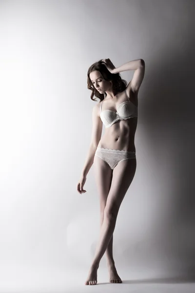 Rêveuse jeune modèle de sous-vêtements posant pieds nus — Photo