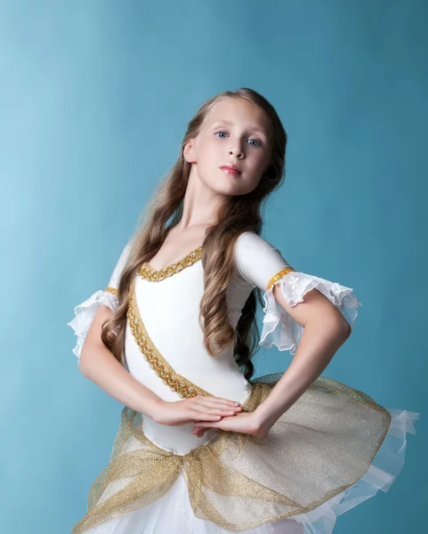 Stolze junge Ballerina posiert vor blauem Hintergrund — Stockfoto