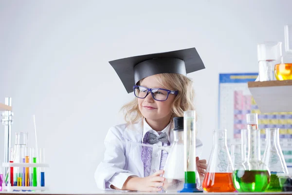 Pequeña colegiala rubia posando en laboratorio — Foto de Stock