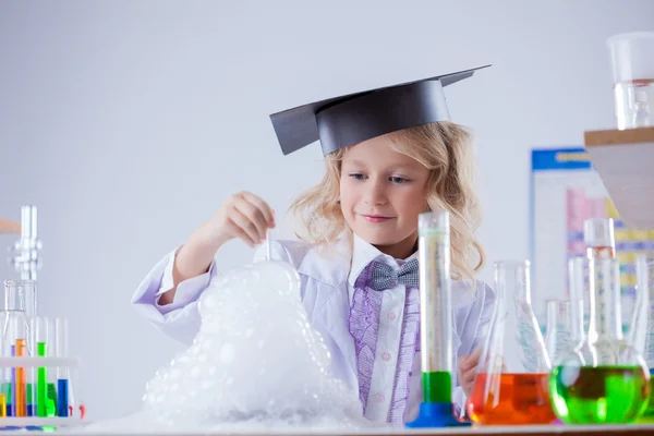 Sonriente lindo químico viendo la reacción química —  Fotos de Stock