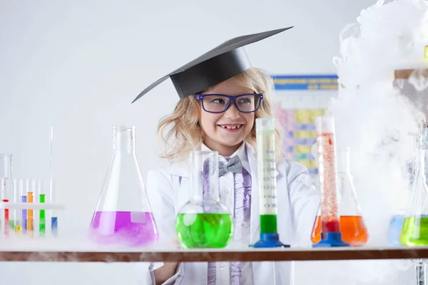 Smiling little chemist puts experiments in lab — Stock Photo, Image