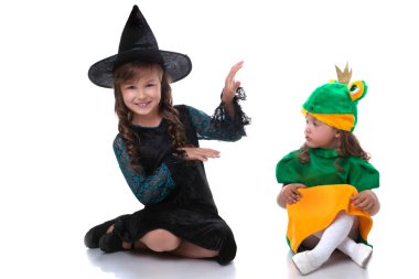 Cute sisters posing in costumes of witch and frog clipart
