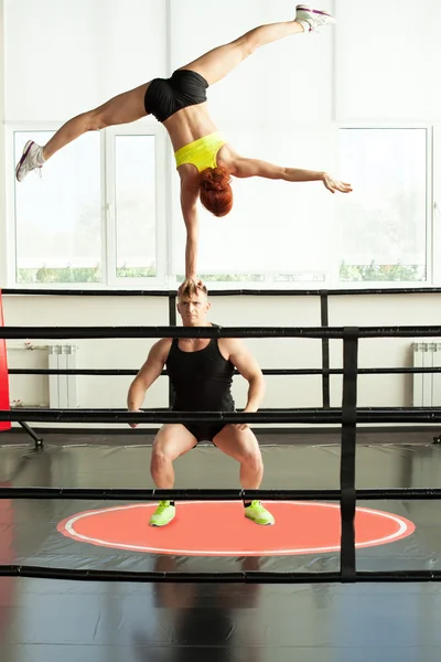 Strong man doing acrobatic rack with his partner — Stock Photo, Image