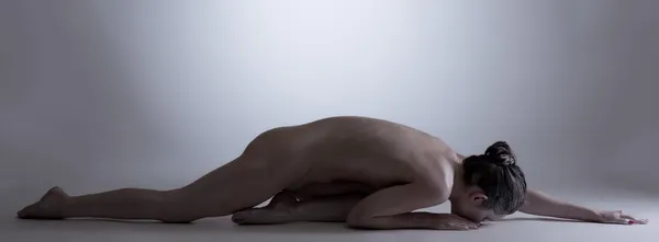 Nude girl with glowing skin posing lying in studio — Stock Photo, Image