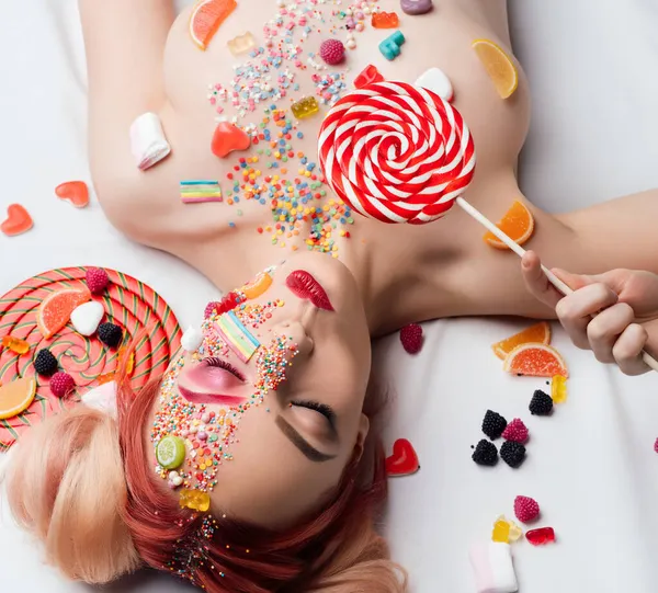 Linda chica desnuda con caramelo en la cara y el cuerpo — Foto de Stock
