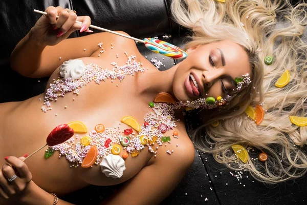 Sexy femme nue dans des bonbons sucrés et avec sucette — Photo