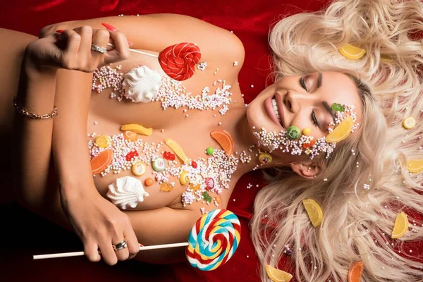 Vidám meztelen nő színes édességekkel borítva — Stock Fotó