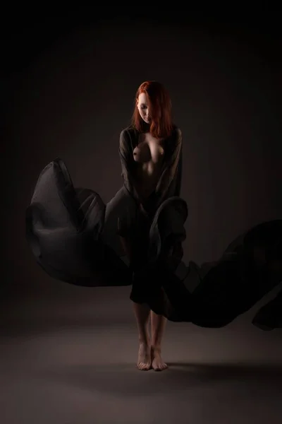 Sensual modelo feminino nu em pé na escuridão e olhando para longe — Fotografia de Stock