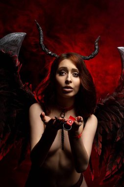 Provocative topless woman with horns and wings