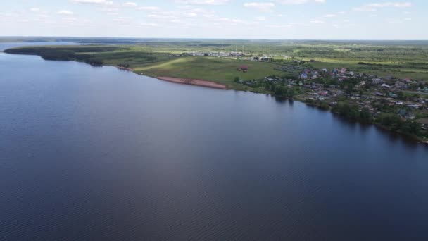 Amplio río azul con pequeño pueblo en la orilla — Vídeos de Stock