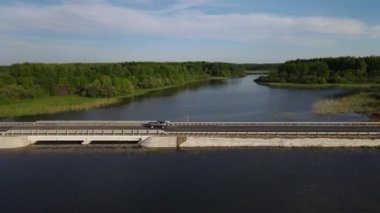 Araçların sakin nehri geçtiği baraj yolu