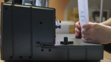 Matbaada ciltleme makinesi kullanan yüzsüz işçi