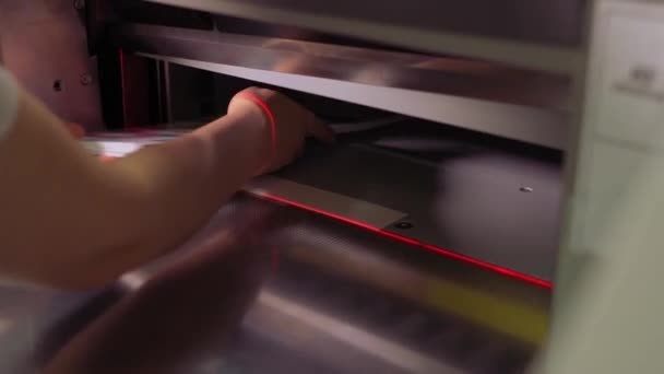 Person working with paper cutter machine in printing house — Stockvideo