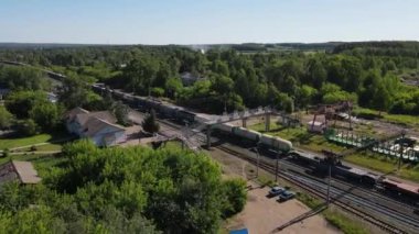 Tren yolu üzerindeki hava manzarası hareket halindeki bir yük treniyle köyden geçiyor.