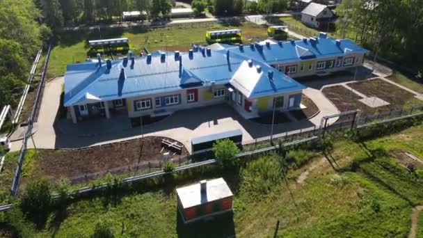 Aerial view on modern Kindergarten building with blue roof in countryside — Stock Video