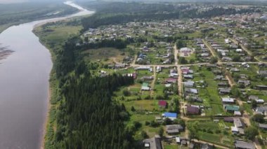 Rusya 'nın Kirov Bölgesi' nde, Nagorsk nehri boyunca uzanan evler ve yeşil ağaçların havadan görünüşü