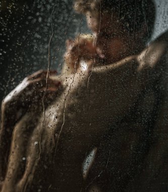 Genç ve tutkulu çiftin duşta seks yaptığı bir stüdyo fotoğrafı.