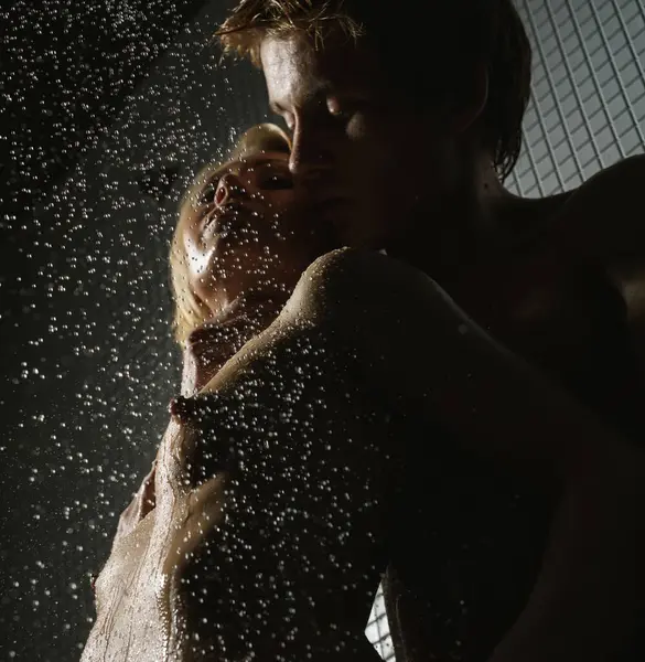 Genç ve tutkulu çiftin duşta seks yaptığı bir stüdyo fotoğrafı.