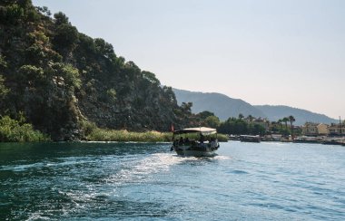 Türkiye'de kayalık yeşil kıyı boyunca tekne yelken bir güneşli yaz gününde vurdu
