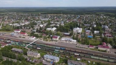 Düşük katlı banliyö evleri ve güneş ışığındaki yeşil ağaçlar, Murashi, Kirov Oblastı arasındaki demiryolu istasyonunun insansız hava aracı görüntüsü