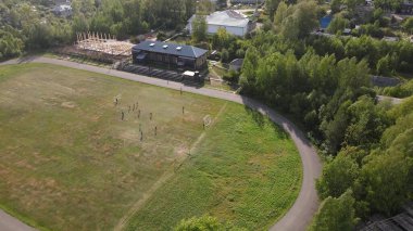 Yeşillik, Nema, Kirov Bölgesi ile küçük bir köy yerleşim yerindeki yeşil alanda futbol oynayan uzak yerel halkın insansız hava aracı görüntüsü