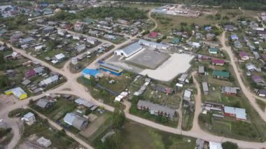 Düşük katlı binaların ve yeşil bitki örtüsü, Podosinovets ve Kirov 'un bulunduğu kırsal alandaki asfaltsız yolların insansız hava aracı görüntüsü