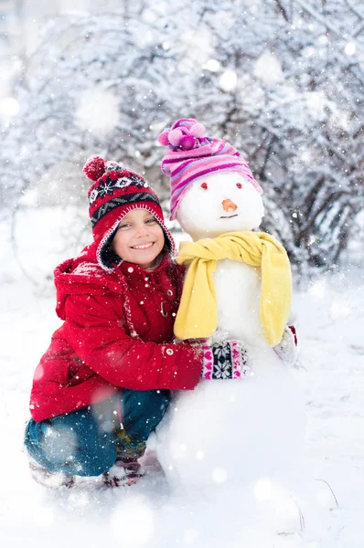 Little girl and snowman — Stock Photo, Image