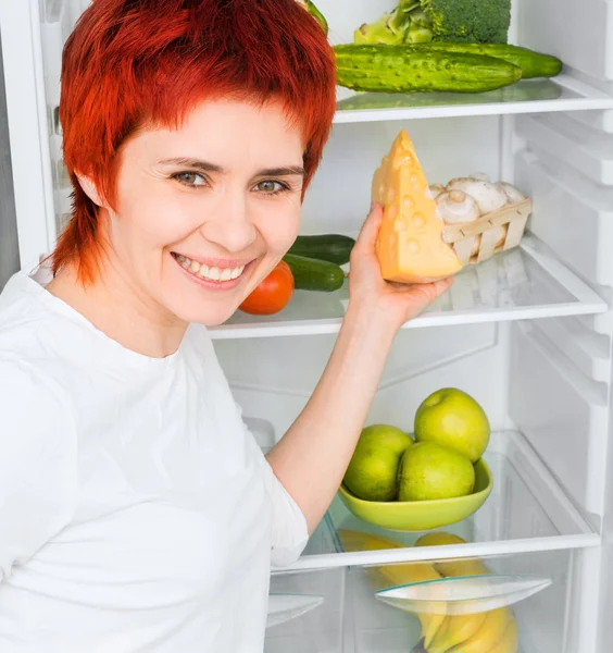 Frau gegen den Kühlschrank — Stockfoto