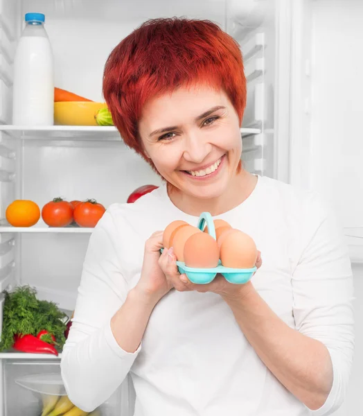 Woman against the refrigerator — Stock Photo, Image