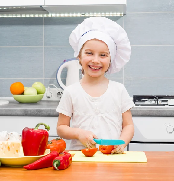 Liten flicka skära tomater — Stockfoto