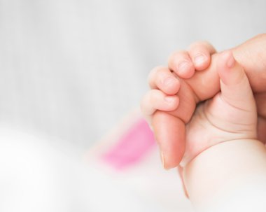 Bebek annenin parmak tutar