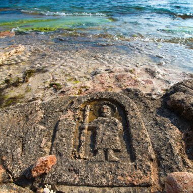 Rock carvings on the beach clipart