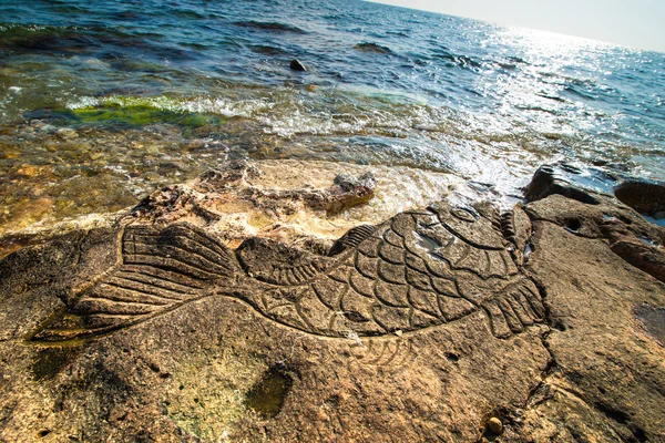 Rock carvings on the beach — Stock Photo, Image