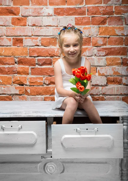 Klein meisje met een boeket bloemen — Stockfoto