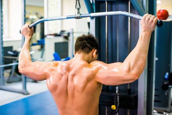 Bodybuilder with simulator — Stock Photo, Image