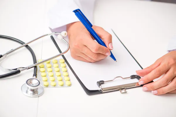 Les mains du médecin avec une table plane — Photo