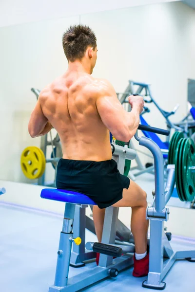 Bodybuilder with simulator — Stock Photo, Image