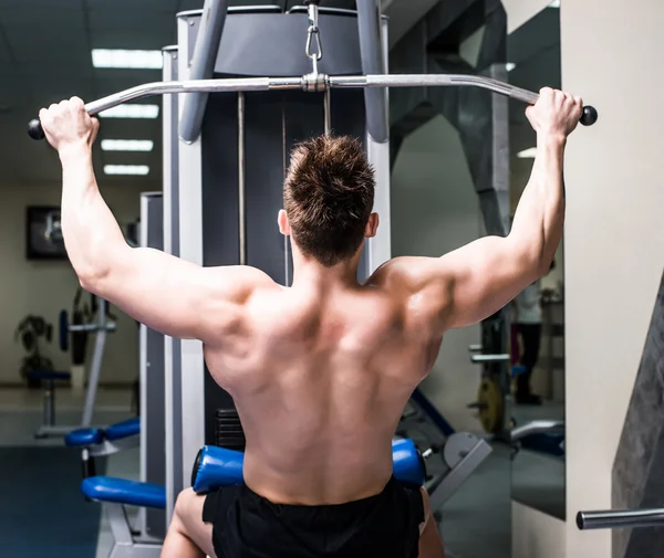 Bodybuilder with simulator — Stock Photo, Image